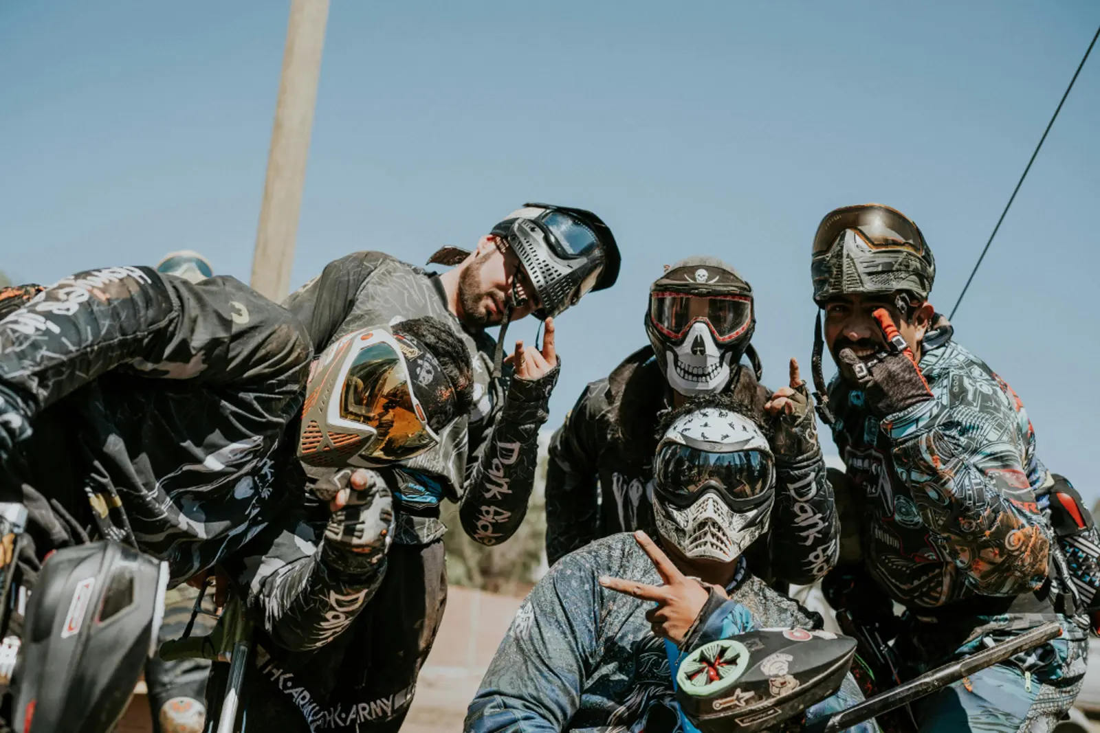 Jugador de paintball agachado tras una barricada durante una pausa de la partida